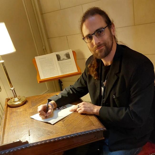 Daniel Z Hastings writing at a desk